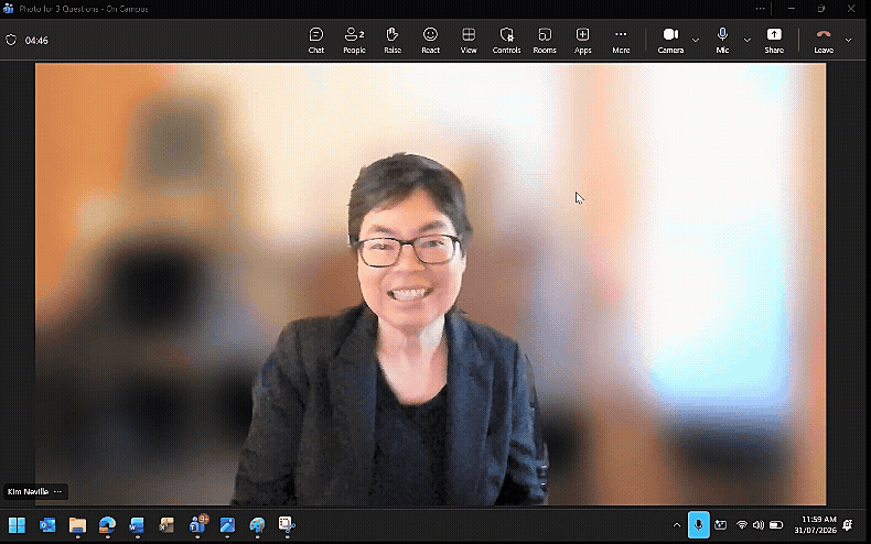 A moving GIF of a computer desktop screen with a video chat open showing Kim Nevile smiling and waving to the camera.